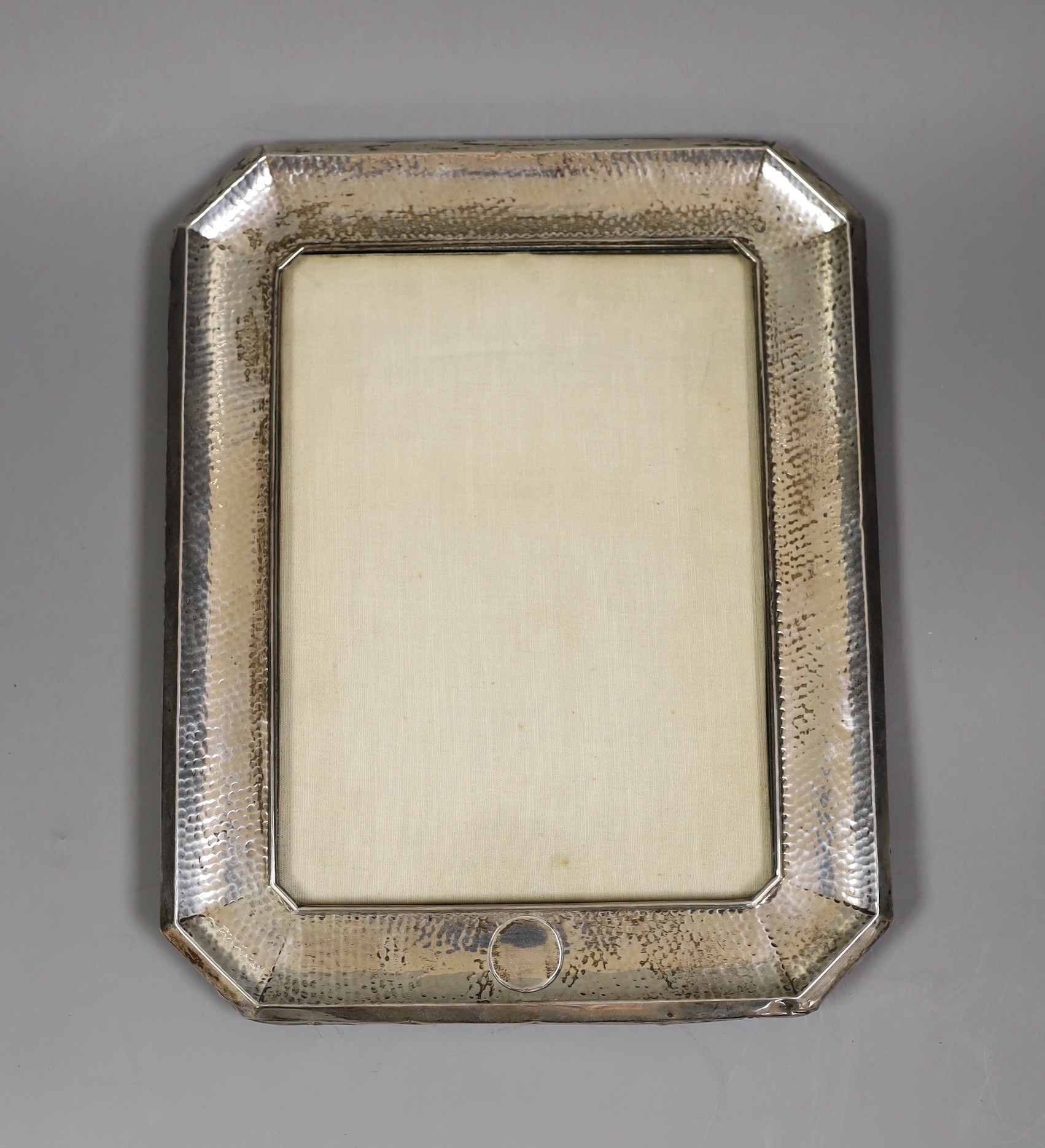 A George V planished silver mounted rectangular photograph frame, with canted corners, Synyer & Beddoes, Birmingham, 1911, 28.1cm, (lacks support arm).